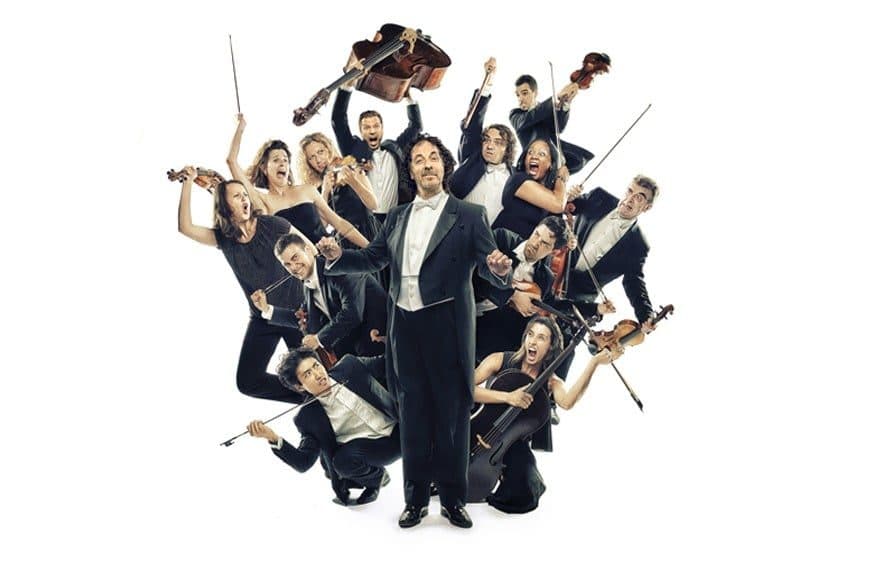 An orchestra of musicians leaping around their conductor with their instruments
