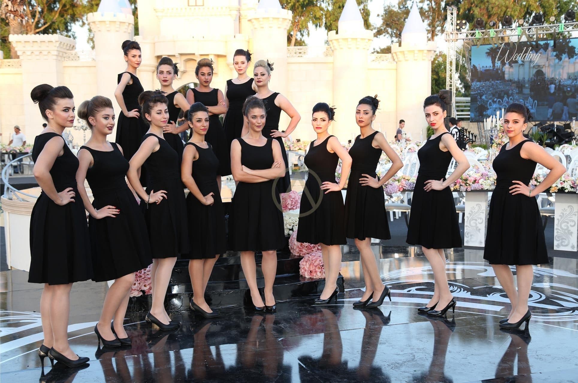 A line of hostesses in black dresses at an event