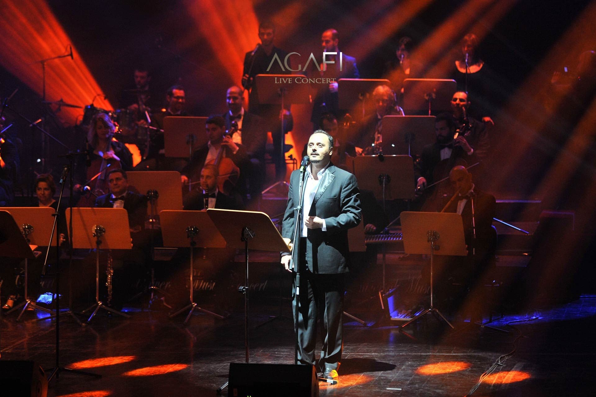 A tenor singing in orange light