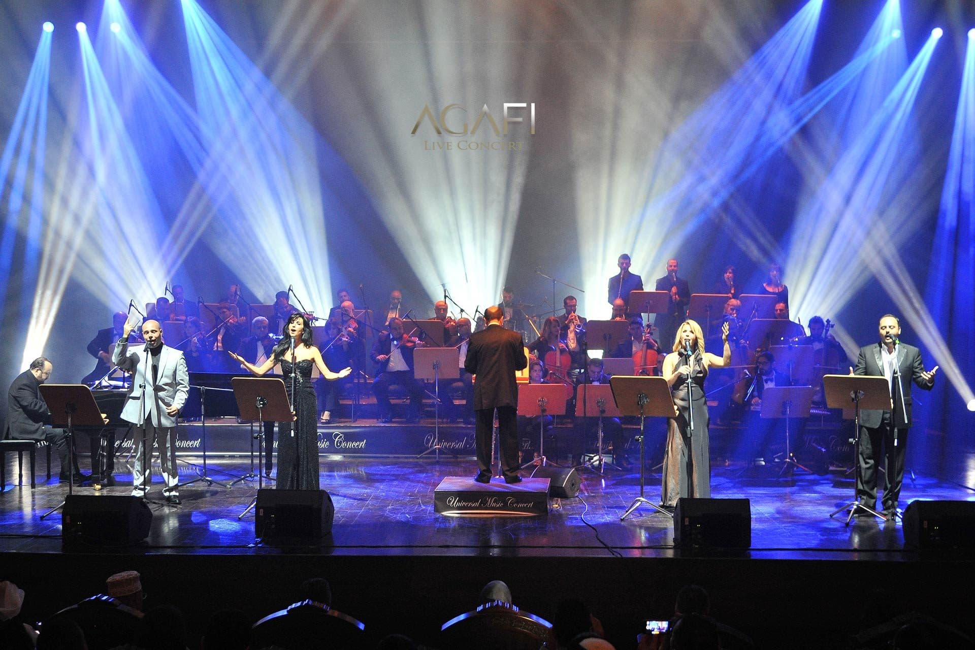 The singers and orchestra under blue beams
