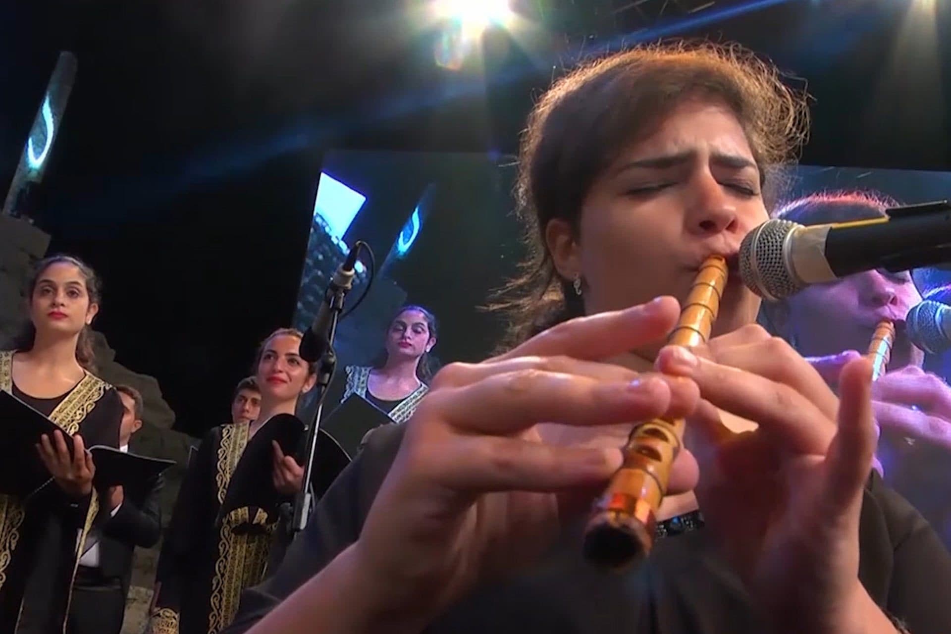 A flute soloist in front of the choir