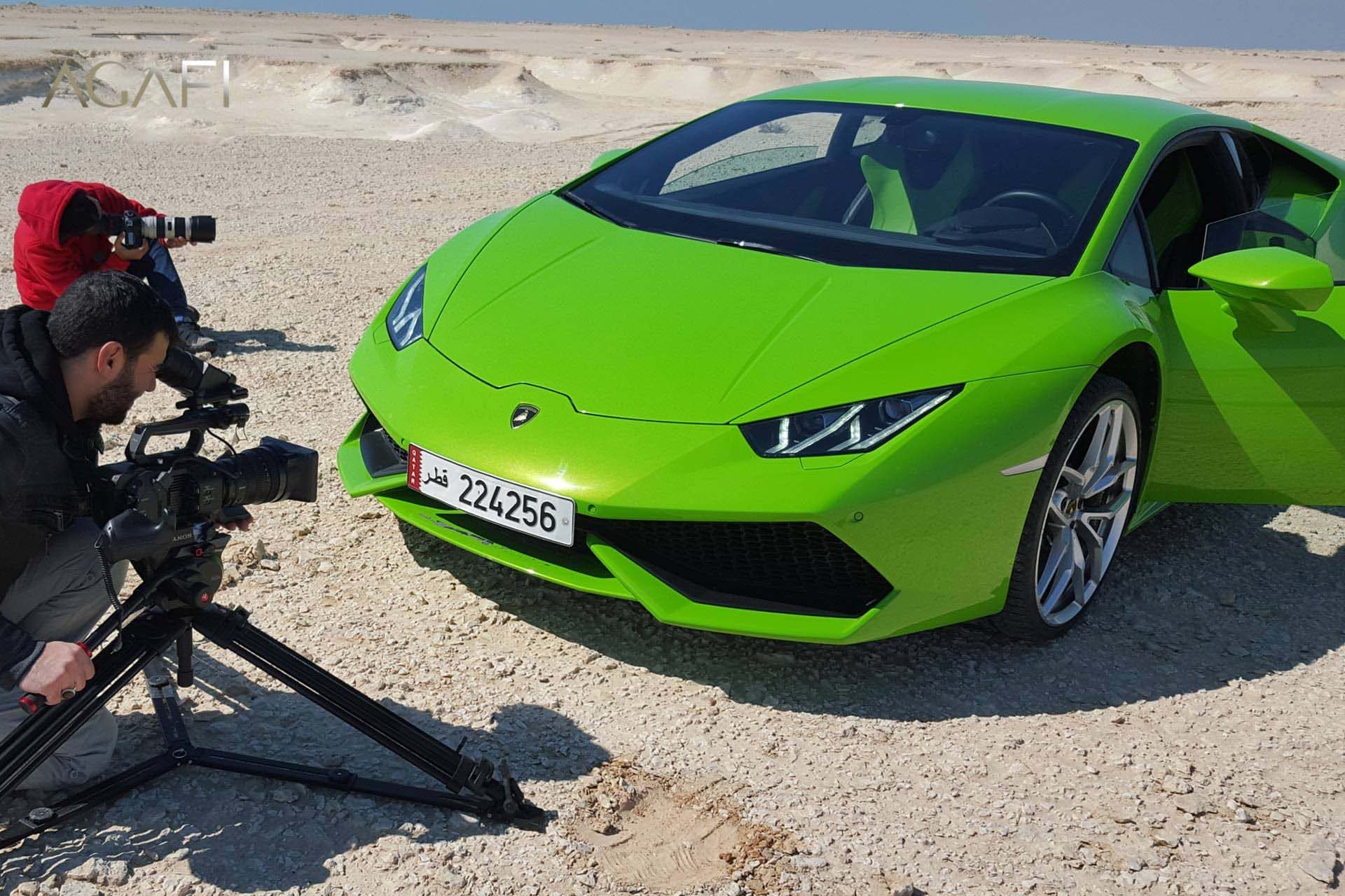A camera operator filming the Lamborghini in the desert