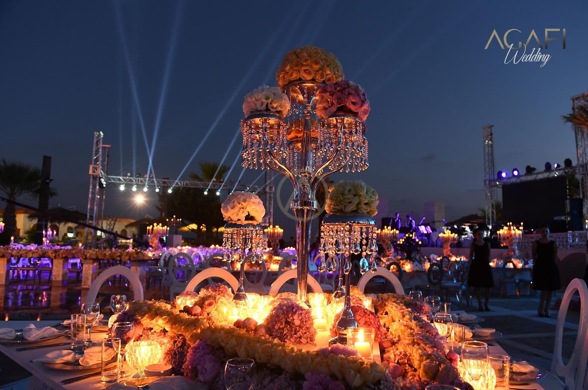 Banquet tables lit at dusk with candles and flowers