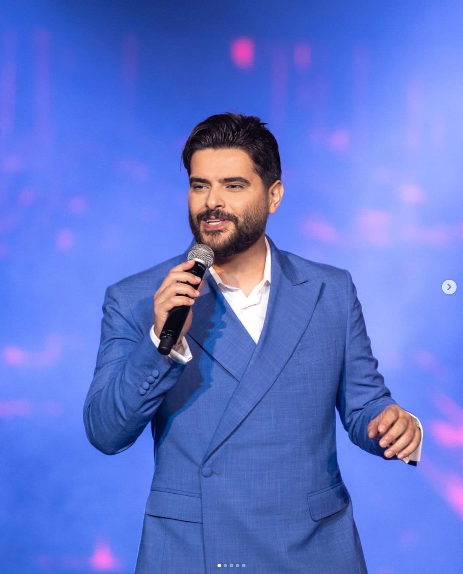 A singer in a blue suit on stage