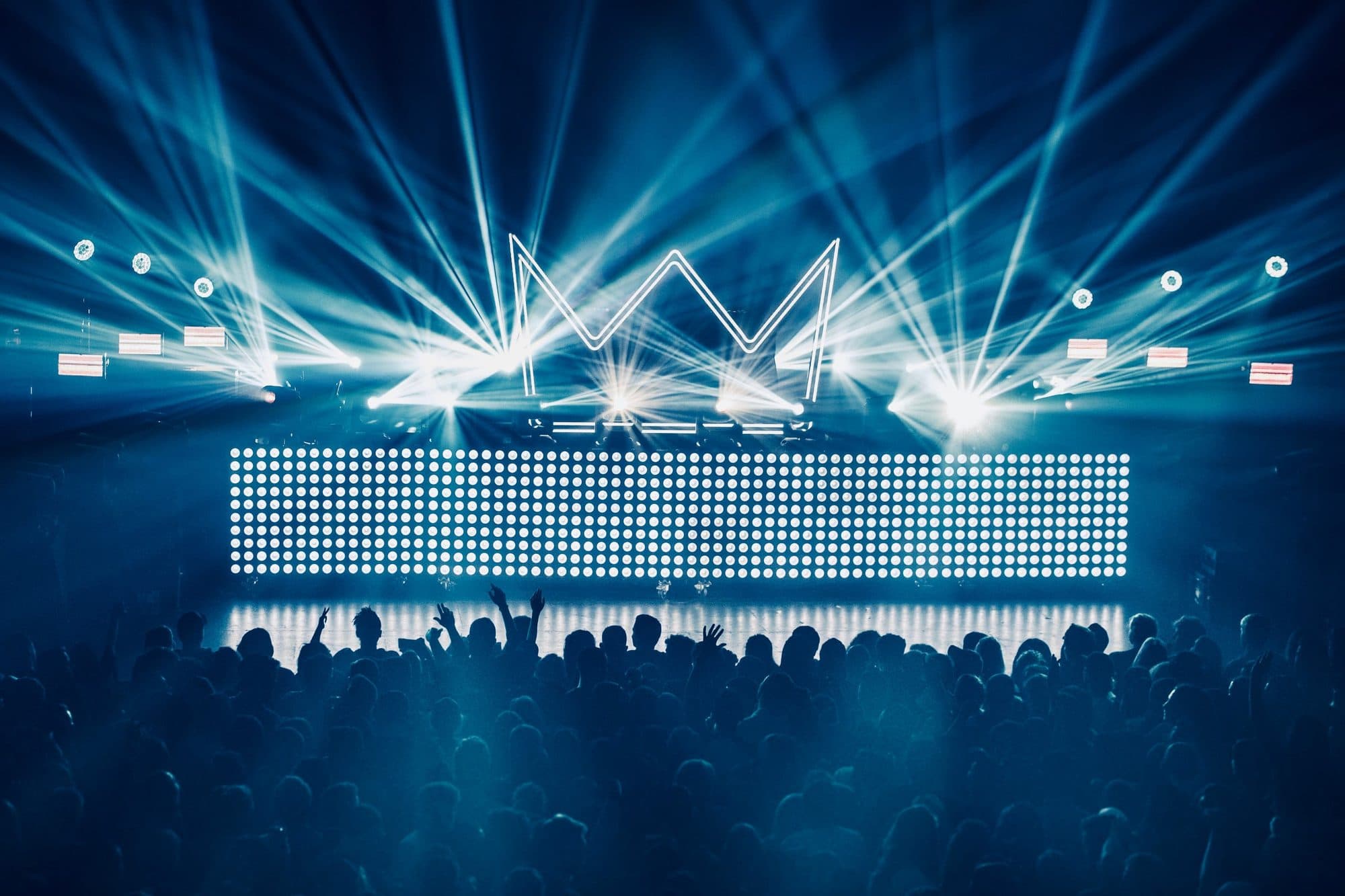 Beams over a crowd in front of an LED wall
