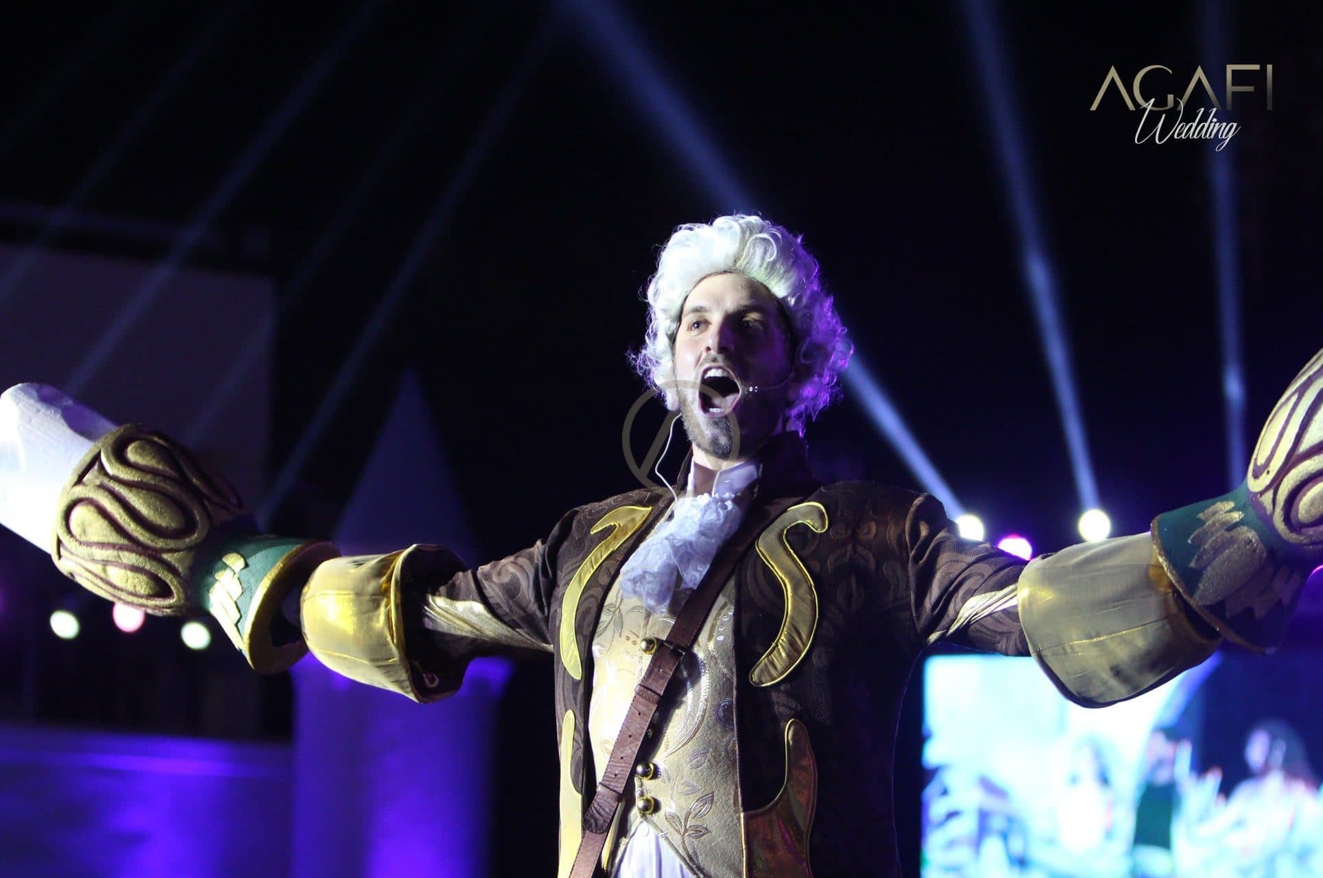 A performer in a baroque costume singing under purple light