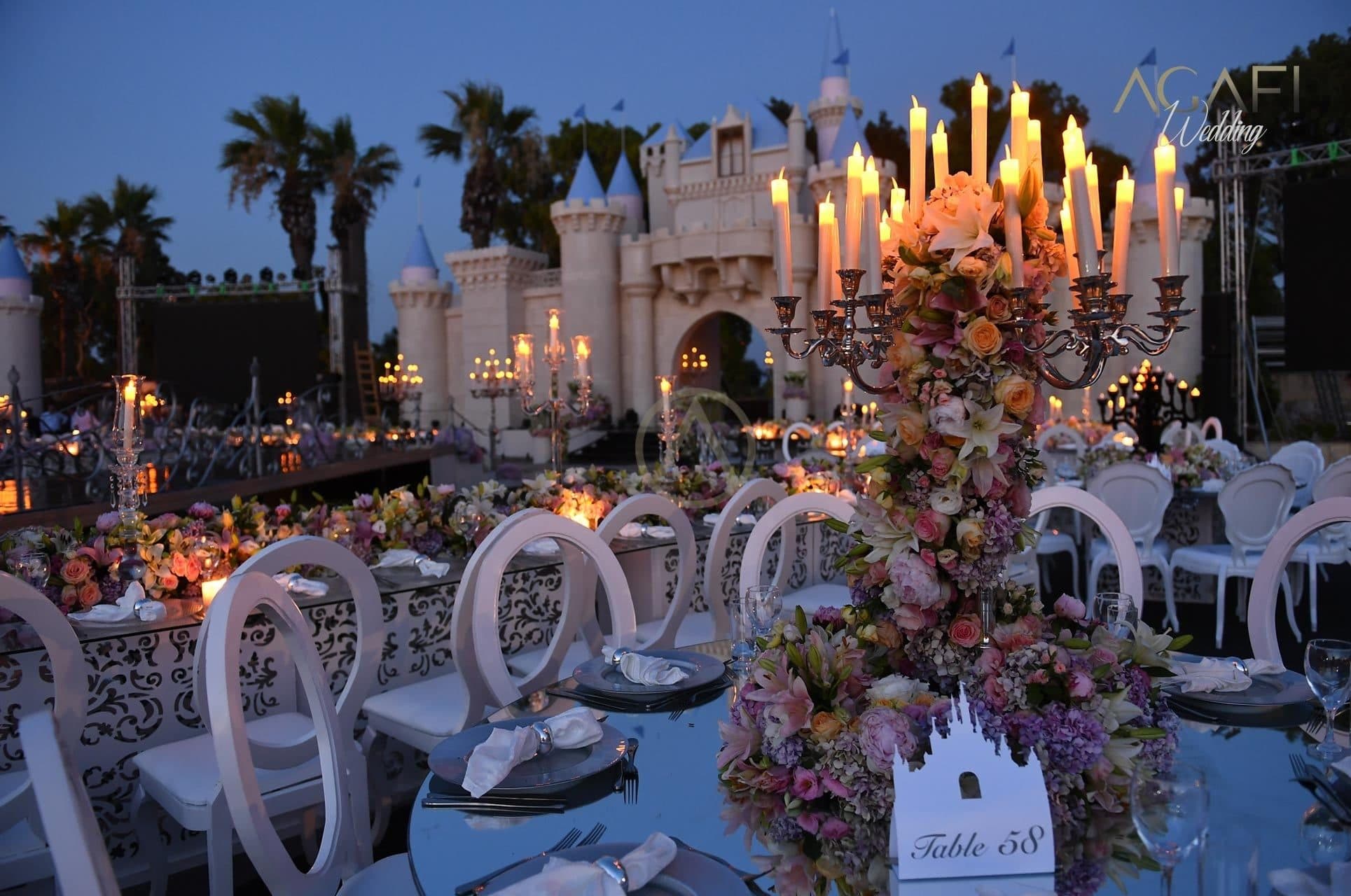 Candles and flowers on the wedding tables in front of the castle